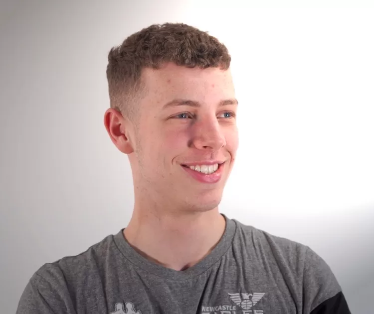 Smiling man with brown hair waring grey t-shirt